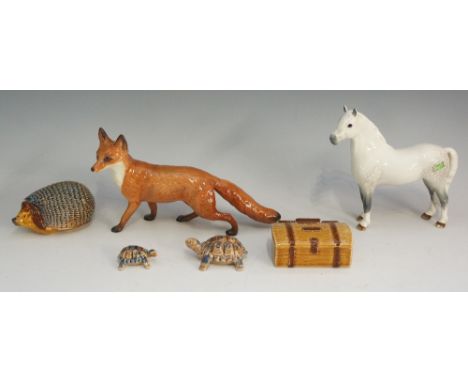 A selection of figurines to include: a Beswick model of a fox, 13cm high, 22.5cm long, marked; a Beswick model of a dabbled g