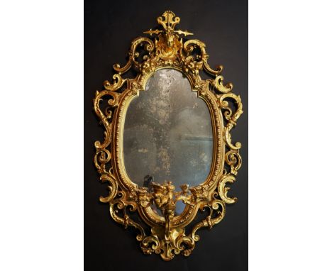 A Victorian giltwood wall mirror in the French taste the de-graded quatrefoil shaped plate within a beaded border and ornate 