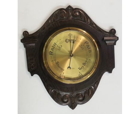An Edwardian oak framed wall barometer the brass dial inscribed Harrison's Opticians Birmingham & Cheltenham bearing registra