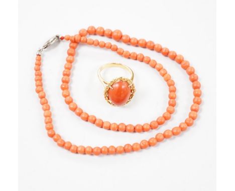 A 1970's 18ct gold and cabochon coral ring, size M, gross weight 6 grams and a coral bead necklace.