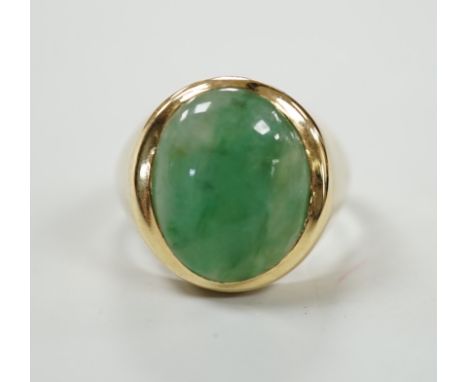 A modern 18ct gold and cabochon oval jade set ring, size P, gross weight 7.1 grams.