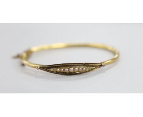 An Edwardian 15ct and graduated seed pearl set hinged bangle, gross weight 7 grams.