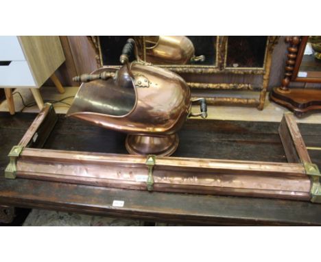 A 19TH CENTURY HELMET SHAPED COPPER COAL SCUTTLE with scoop, 44cm high, together with a brass &amp; copper kerb fender, 102cm