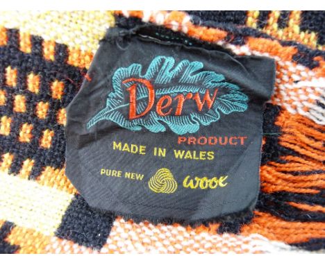 A VINTAGE WELSH WOOLLEN BLANKET with 'Derw' label in red, black and yellow traditional pattern tones (some staining and imper
