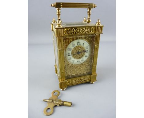 A FRENCH GILT BRASS FOUR PANE CARRIAGE CLOCK, ivorine dial in a foliate mask, the case with pierced side panels and reeded co