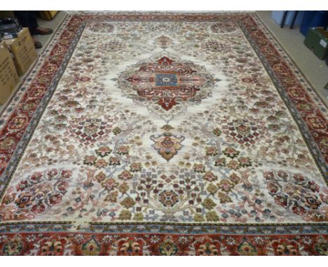 A GOOD EASTERN WOOLLEN CARPET with central medallion on a cream ground, repeating tree pattern and triple coloured border wit