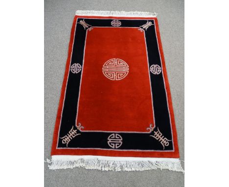 Oriental woolen red and black carpet with medalion designs and tassle ends 200 x 120cms