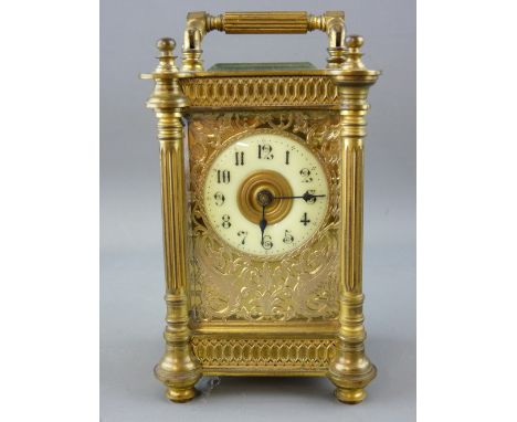 AN ORNATE FRENCH GILT BRASS CARRIAGE CLOCK with visible escapement and pierced fret front, in original carry case with key