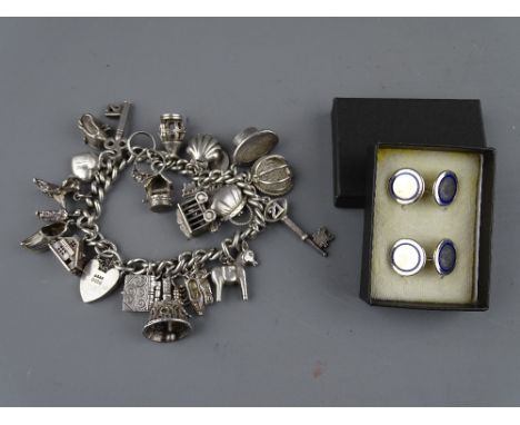 A SILVER CHARM BRACELET with twenty one charms, 2.8 troy ozs and a pair of Tiffany sterling silver and blue enamel gent's cir