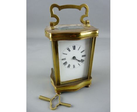 A FRENCH SERPENTINE BRASS CASED CARRIAGE CLOCK, the backplate marked 'Made in France', 15.5 cms high handle up, with key