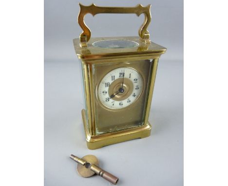 A FRENCH BRASS CASED CARRIAGE CLOCK, enamel dial with gilt centre and mask, 14.25 cms high handle up, with key