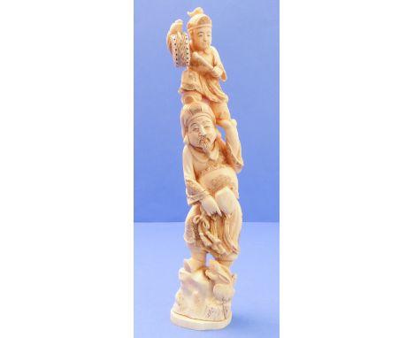 A well-carved early 20th century Japanese ivory Okimono figure group: corpulent male figure holding a drummer boy, below a st