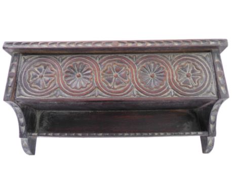 A vernacular Folk Art style set of oak hanging shelves; chip carved top above a hinged compartment carved in 17th century sty