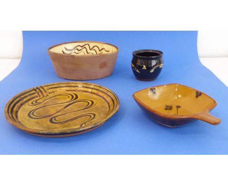 Four pieces of slipware decorated Winchcombe Pottery:an oval slipware dish decorated with a simple scrafitto pattern and lead