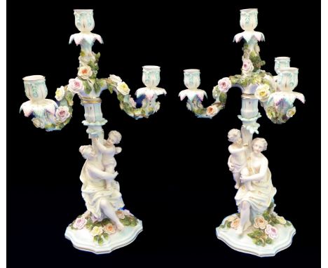 A pair of 19th century Dresden two-piece candelabra: removable four-arm candle holders over a female figure in classical dres