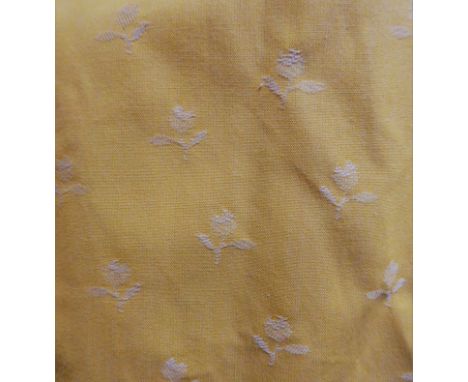A pair of yellow curtains with woven small floral pattern, edged with corded and fringed braid, triple pinch pleat heading, w