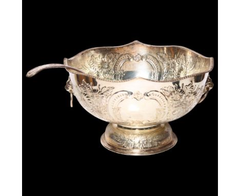 A large silver plate on copper punch bowl and ladle, with repousse decoration and lion mask ring handles, on turned foot, H20