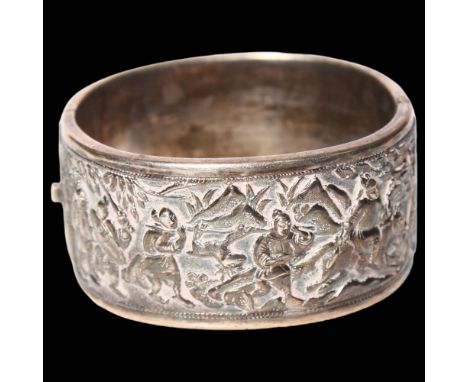 A Chinese embossed silver hinged bangle, panels decorated with hunting figures, with maker's mark for Wang Hing 