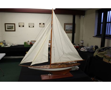 Large scale wooden model of a yacht, with sails and rigging on a stand, 110cm high and 104cm long 