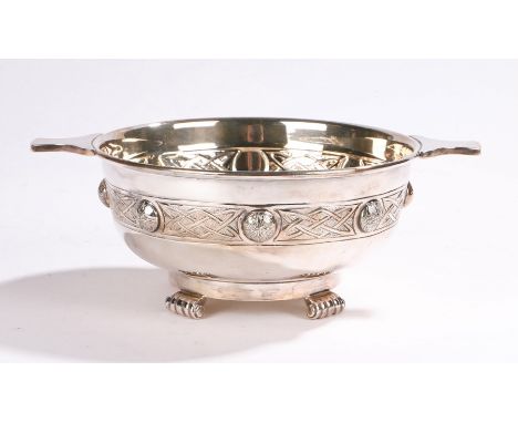 Celtic inspired silver plated bowl, with shaped handles above a Celtic central band, raised on four reeded scrolled feet, 24.