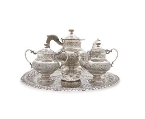 AN ANGLO-BURMESE WHITE METAL FIVE PIECE TEA SERVICE, comprising tea pot, lidded creamer, two handled sugar bowl and cover, te