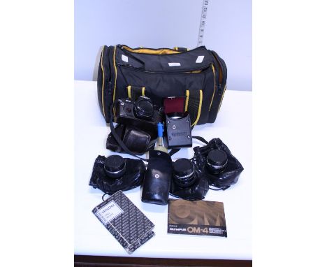 A Olympus OM4 35mm camera with four assorted lenses and other accessories 