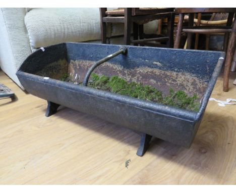 Victorian era cast iron animal feeder trough with centre strap/handle, bracket feet. Has been used as planter. Very heavy.  H