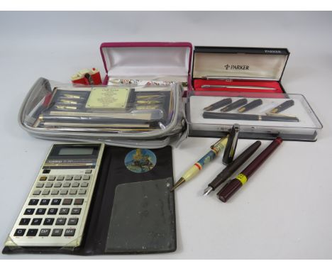 Selection of various pens and a vintage casio calculator.