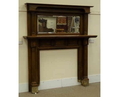 Edwardian oak fire-surround, raised bevel edge mirror back, projecting moulded cornice above single shelf with dentil frieze,