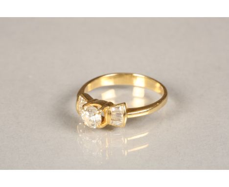 18 carat yellow gold diamond ring in a bow setting, centre stone 0.3 carat brilliant cut diamond with three baguette cut diam