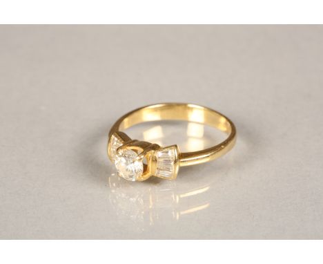 18 carat yellow gold diamond ring in a bow setting, centre stone 0.3 carat brilliant cut diamond with three baguette cut diam