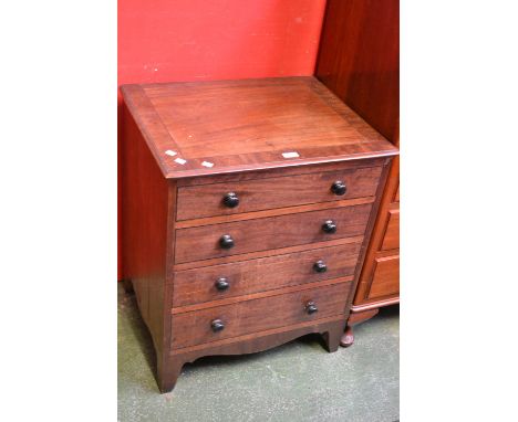 A George III mahogany commode in the form of a four drawer chest.