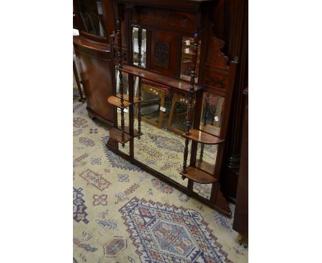 An Edwardian mahogany over mantel, stepped cornice, dentil frieze, an arrangement of five mirrors, shelves and columns, ceram