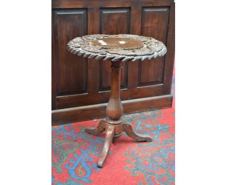 An oak tripod, circular top carved in relief with fruiting vines, turned column, cabriole legs. 53cm high x 45cm diameter.