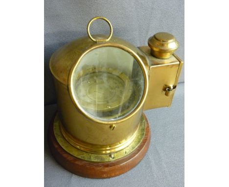Brass ship's type gimbal compass with side lamp, mounted on a circular wooden base, 27 cms high