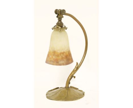 A brass table lamp,with a lily pad base, fitted with a mottled amber, yellow and orange shade, inscribed 'Muller Frères',35.5