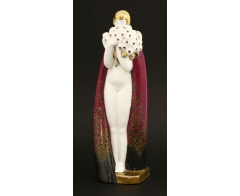 An Art Deco porcelain table lamp,by Robj, Paris, modelled as a lady smelling a bunch of flowers wearing an ermine-trimmed rob