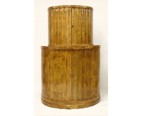 An Art Deco burr maple drinks cabinet,of fluted demilune form, the upper section with a mirrored back and glass shelves, over