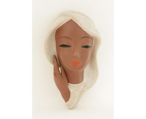 A Goldscheider terracotta pottery wall mask, designed by Kurt Goebel, of a lady with a veil with red lips and a red ring, pri