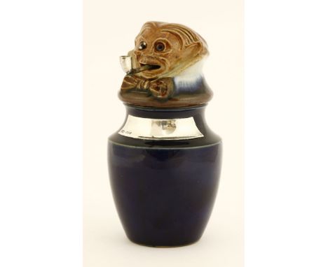 A Royal Doulton stoneware tobacco jar and cover,modelled as a figure wearing a bow tie with a pipe in his mouth, silver label