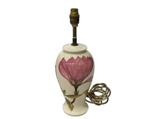 Moorcroft Pottery table lamp decorated with magnolia on cream ground.