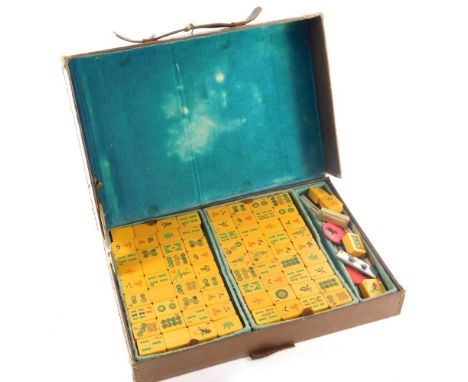 A Mahjong set, in leather case with resin pieces, the case 28cm wide. 