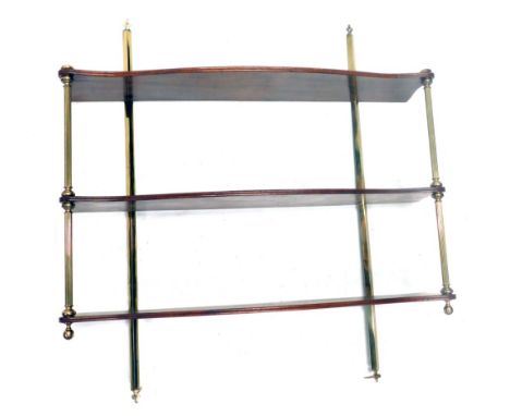 A mahogany and brass wall shelf, with three shaped tiers, on reeded pillar supports, 80cm high, 76cm wide.