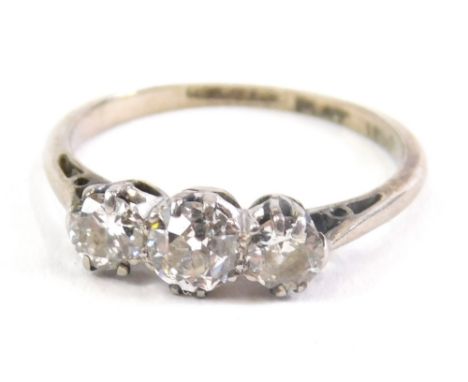 A three stone diamond ring, on part pierced shank, illusion set, marked PLAT, size J, 1.9g all in.