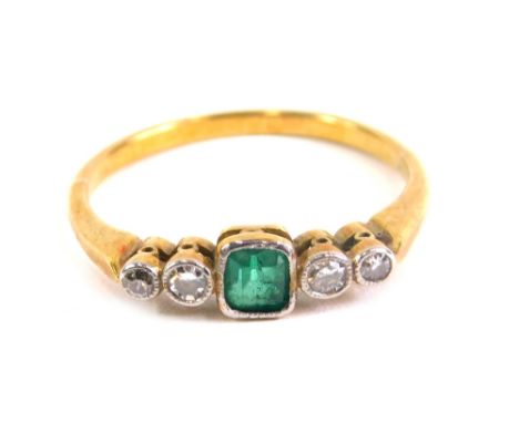 An Art Deco style dress ring, baguette cut with central emerald flanked by two small diamonds on an unmarked shank, size M.