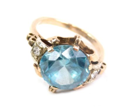 A dress ring, claw set with a large blue zircon, the part pierced shank inset with two diamonds, unmarked, size M.