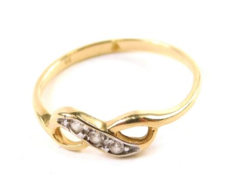 A dress ring, of figure of eight form set with four small white stones, on a white and yellow metal setting, partially pierce