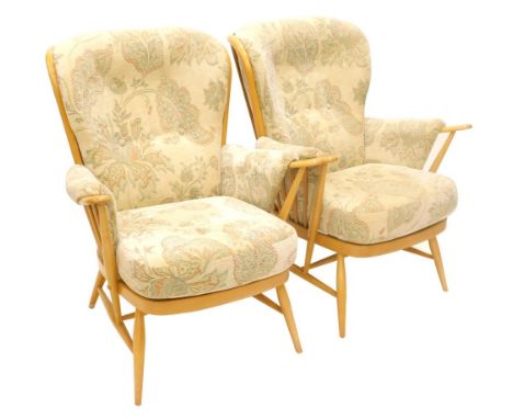 A pair of Ercol light beech spindle back armchairs, with padded backs, arm rests and seats, design no. 914. The upholstery in