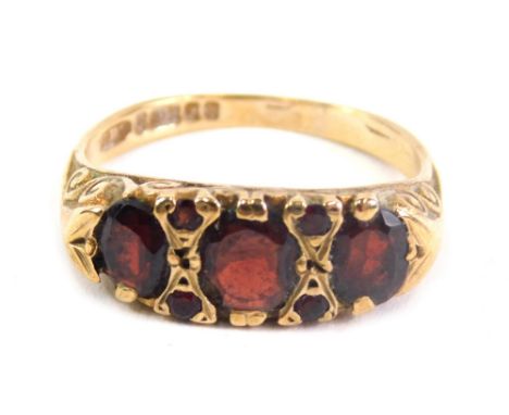 A 9ct gold dress ring, set with four large and four small garnets, size K.