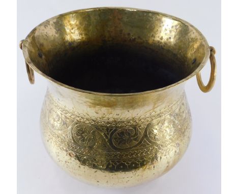 An early 20thC brass Eastern jardiniere, with bulbous body, decorated with scrolls and flowers with ring handles, 32cm diamet